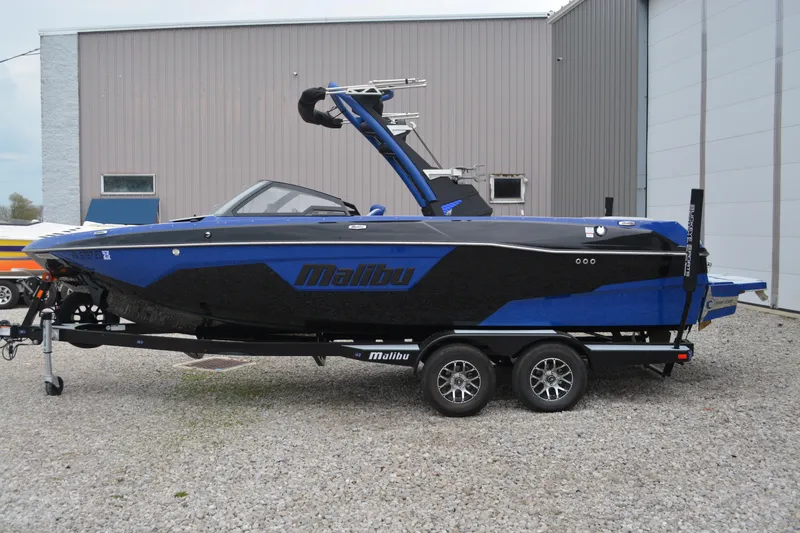 Slide: The Image of 2022 Malibu Wakesetter 23 LSV boat in blue and black on a trailer. - 4