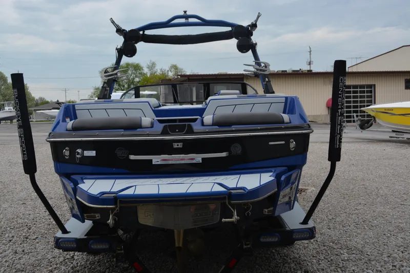 Slide: The Image of 2022 Malibu Wakesetter 23 LSV boat, rear view, blue color, parked on gravel. - 5