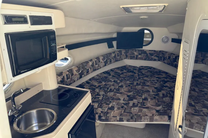 Slide: The Image of Interior of 2002 Rinker Fiesta Vee 270 boat with kitchenette and cozy seating area. - 13