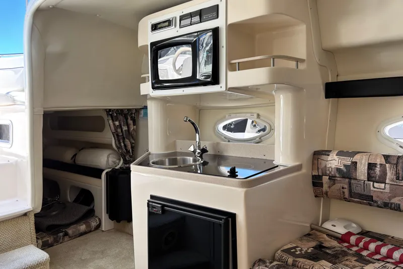 Slide: The Image of 2002 Rinker Fiesta Vee 270 cabin interior with kitchenette and seating area. - 15