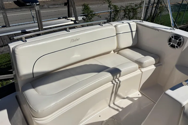 Slide: The Image of 2002 Rinker Fiesta Vee 270 boat interior with white seating and speaker. - 7