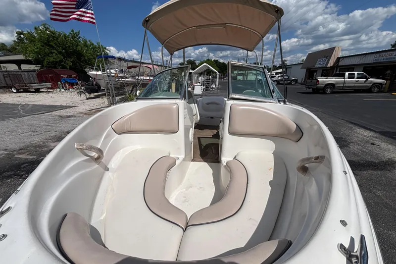 Slide: The Image of 2002 Sea Ray 176 Bow Rider boat with beige seating, docked under a sunny sky. - 10