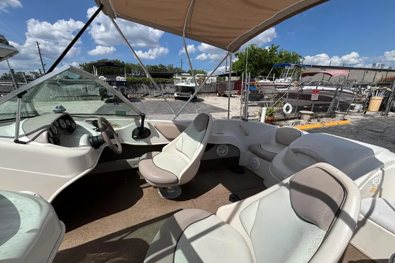 Slide: The Image of 2002 Sea Ray 176 Bow Rider interior with seating and steering wheel under canopy. - 11