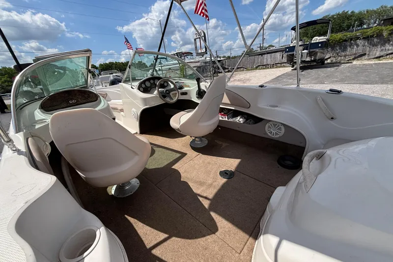 Slide: The Image of 2002 Sea Ray 176 Bow Rider interior with seating and steering wheel, under a sunny sky. - 15