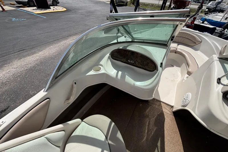 Slide: The Image of 2002 Sea Ray 176 Bow Rider interior with seating and windshield, parked on pavement. - 21