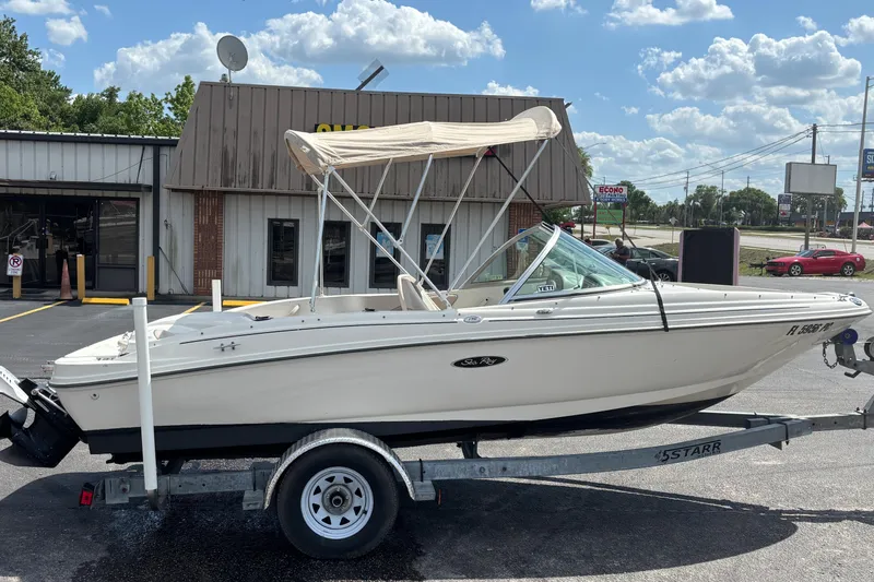 Slide: The Image of 2002 Sea Ray 176 Bow Rider boat on trailer, parked outside a building under a sunny sky. - 5