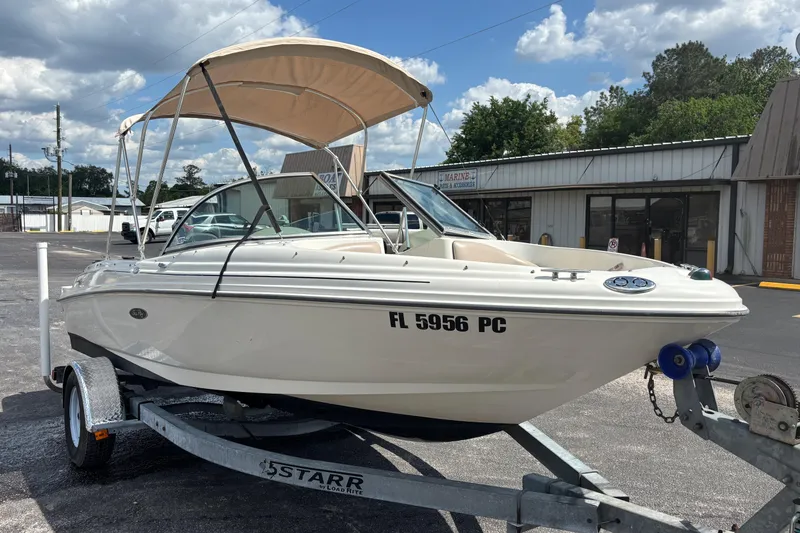Slide: The Image of 2002 Sea Ray 176 Bow Rider boat on trailer, parked outdoors under a cloudy sky. - 6