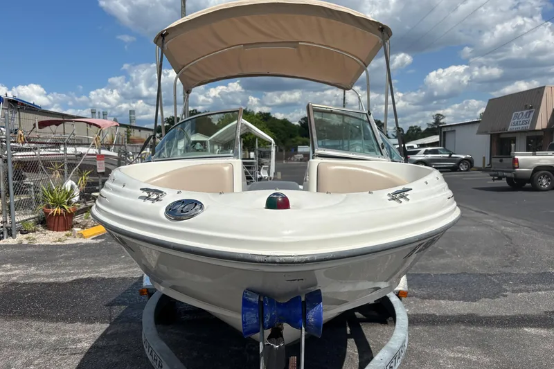 Slide: The Image of 2002 Sea Ray 176 Bow Rider boat with canopy on trailer, parked outdoors. - 7