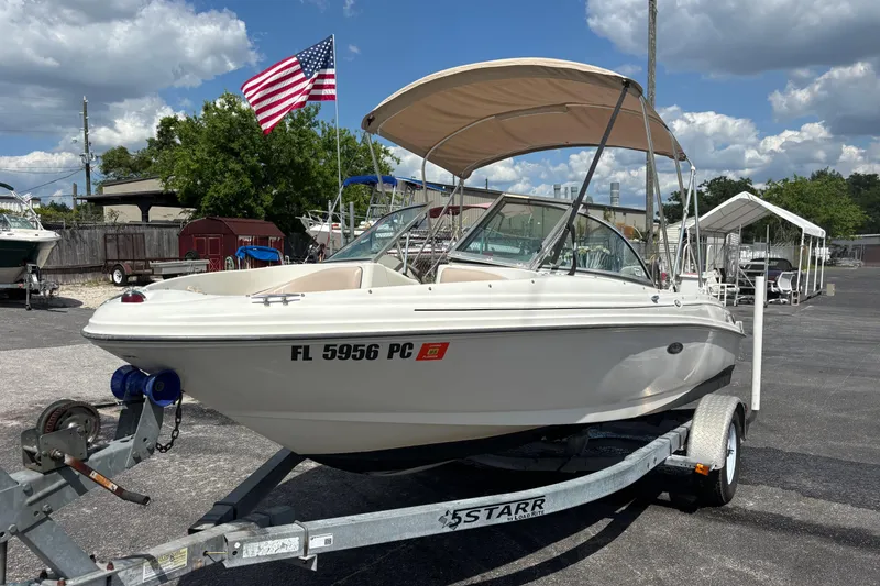 Slide: The Image of 2002 Sea Ray 176 Bow Rider boat on trailer with American flag in background. - 8