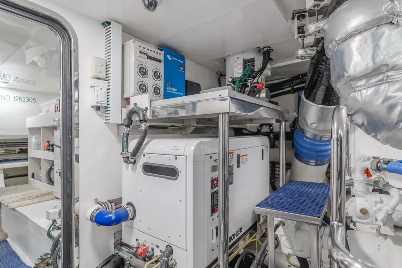 Slide: The Image of Engine room of 2015 Ocean Alexander 72 Pilothouse yacht, featuring Kohler generator and control panels. - 13