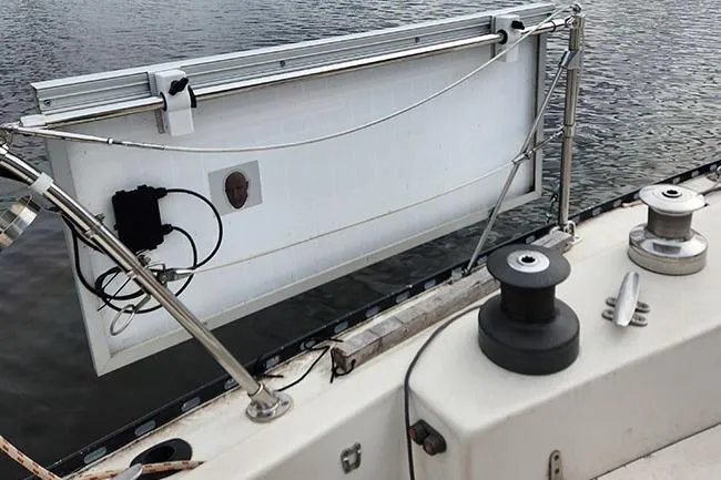 Slide: The Image of 1977 C&C 29 sailboat with solar panel installation on deck by the water. - 14