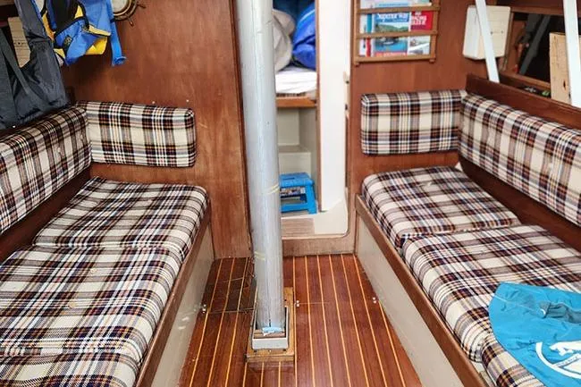 Slide: The Image of Interior of a 1977 C&C 29 sailboat with plaid seating and wooden flooring. - 3