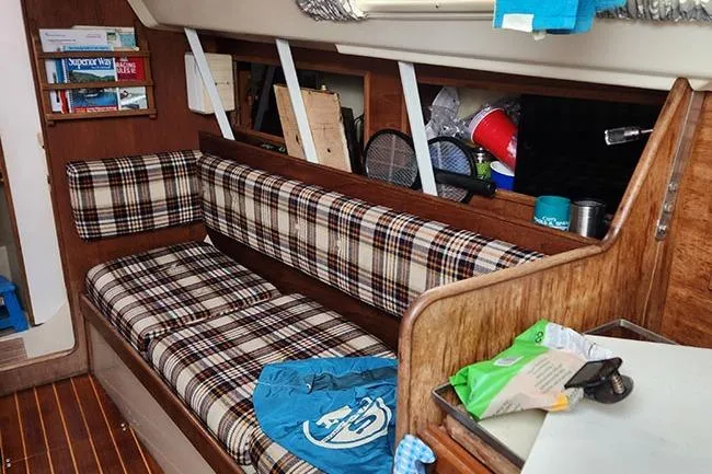 Slide: The Image of Interior of a 1977 C&C 29 sailboat with plaid seating and wooden accents. - 4