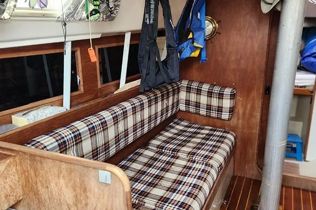 Slide: The Image of Interior of a 1977 C&C 29 sailboat with plaid seating and wooden finishes. - 5
