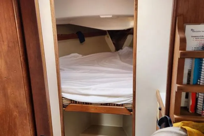 Slide: The Image of Cozy cabin interior of a 1977 C&C 29 sailboat with a neatly made bed. - 9