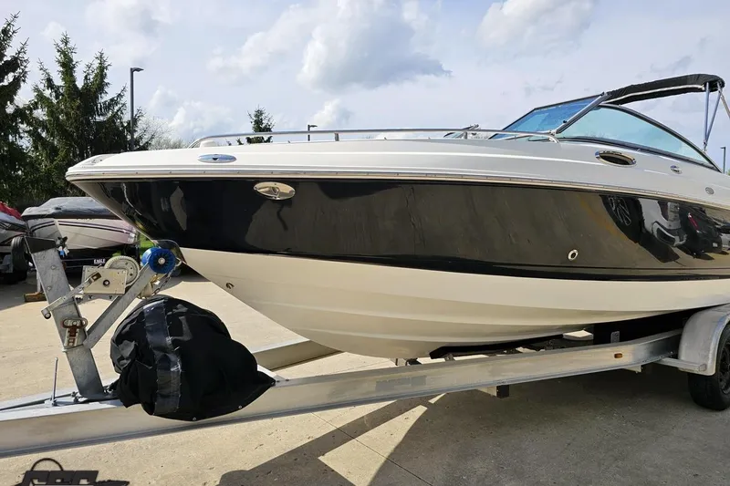 Slide: The Image of 2007 Chaparral 256 SSi boat on trailer, black and white hull, parked outdoors. - 17