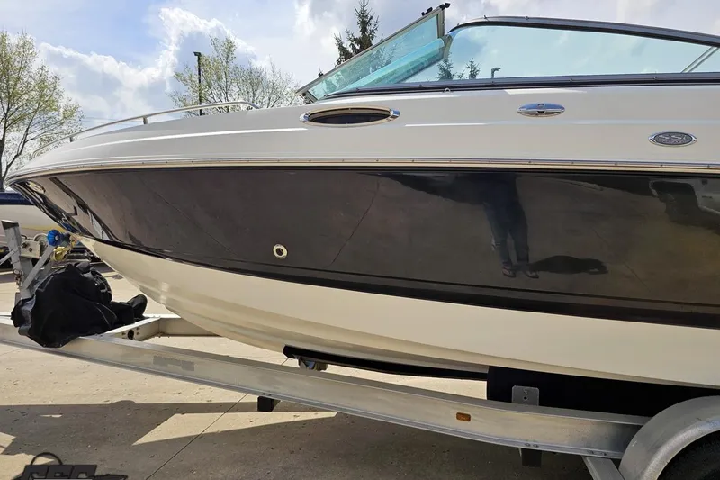 Slide: The Image of 2007 Chaparral 256 SSi boat on trailer, sleek black and white design, outdoors. - 21