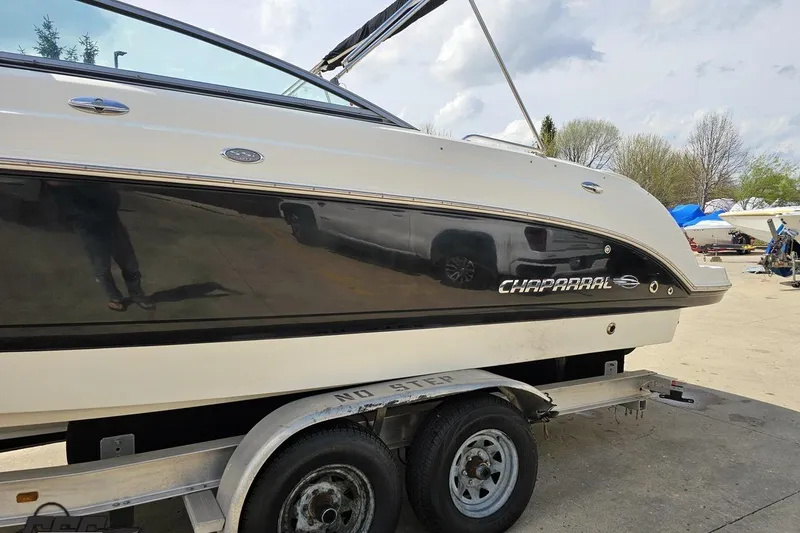 Slide: The Image of 2007 Chaparral 256 SSi boat on trailer, side view with sleek black and white design. - 22