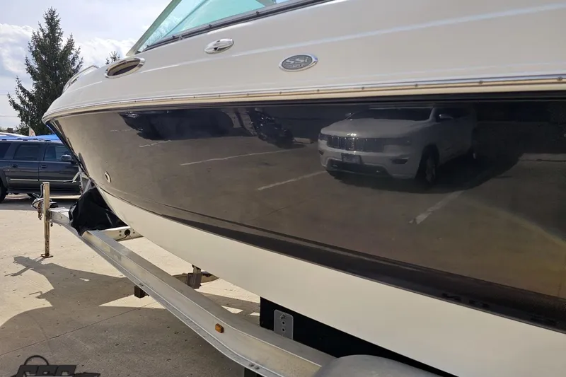 Slide: The Image of 2007 Chaparral 256 SSi boat on trailer, parked outdoors, reflecting nearby vehicles. - 24