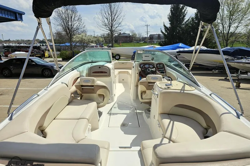 Slide: The Image of 2007 Chaparral 256 SSi boat interior with beige seating and dashboard, parked outdoors. - 30