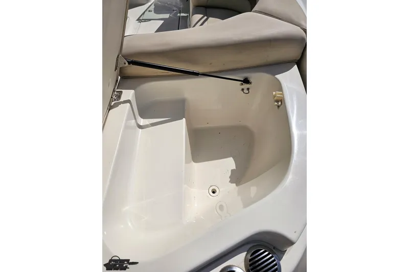 Slide: The Image of Open storage compartment in 2007 Chaparral 256 SSi boat, featuring beige seating and hydraulic support. - 34