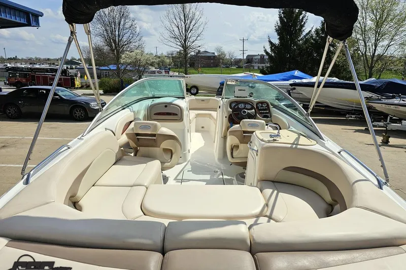 Slide: The Image of 2007 Chaparral 256 SSi boat interior with beige seating and dashboard, parked outdoors. - 40