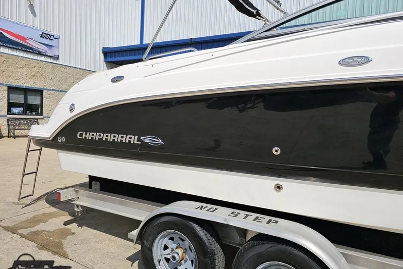 Slide: The Image of 2007 Chaparral 256 SSi boat on trailer, black and white exterior, parked outside a building. - 5
