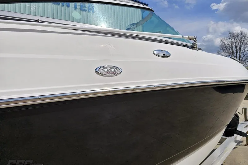 Slide: The Image of 2007 Chaparral 256 SSi boat side view with emblem, under a partly cloudy sky. - 6