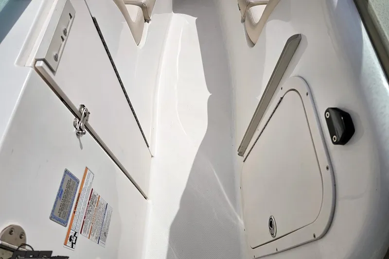 Slide: The Image of 2007 Chaparral 256 SSi boat interior with storage compartments and safety labels. - 66