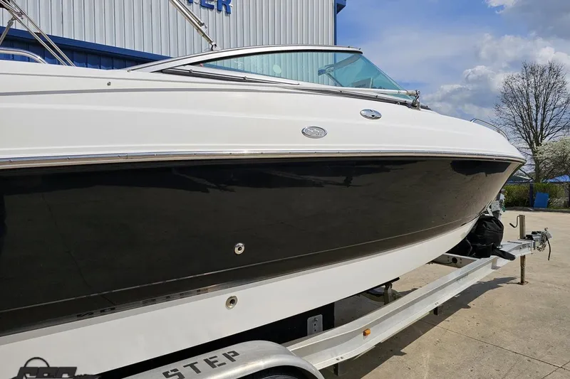 Slide: The Image of 2007 Chaparral 256 SSi boat on trailer, sleek black and white design, outdoors. - 7