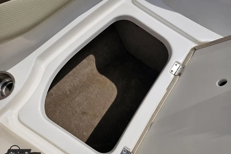 Slide: The Image of Storage compartment in a 2007 Chaparral 256 SSi boat, featuring a carpeted interior. - 75