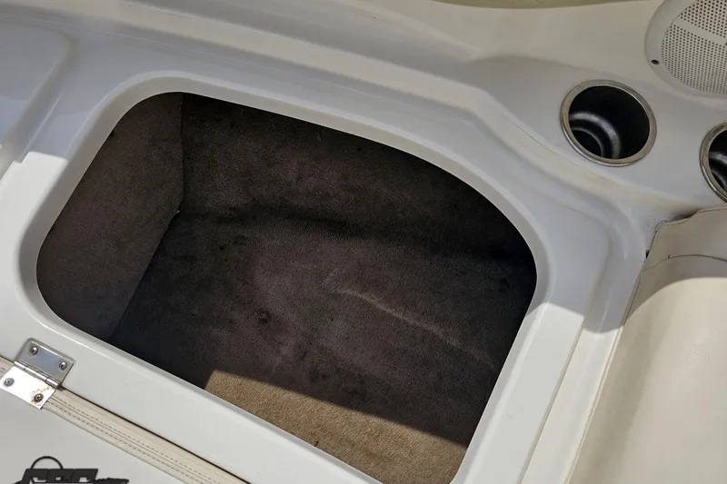 Slide: The Image of Storage compartment in a 2007 Chaparral 256 SSi boat, featuring cup holders and speaker. - 76