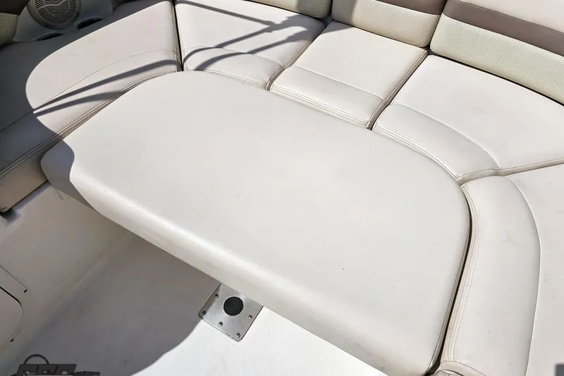 Slide: The Image of 2007 Chaparral 256 SSi boat interior seating, featuring white cushioned upholstery. - 84