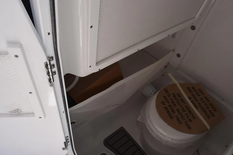 Slide: The Image of Interior of 2026 Sea Hunt Ultra 275 SE boat, featuring a compact marine toilet. - 15