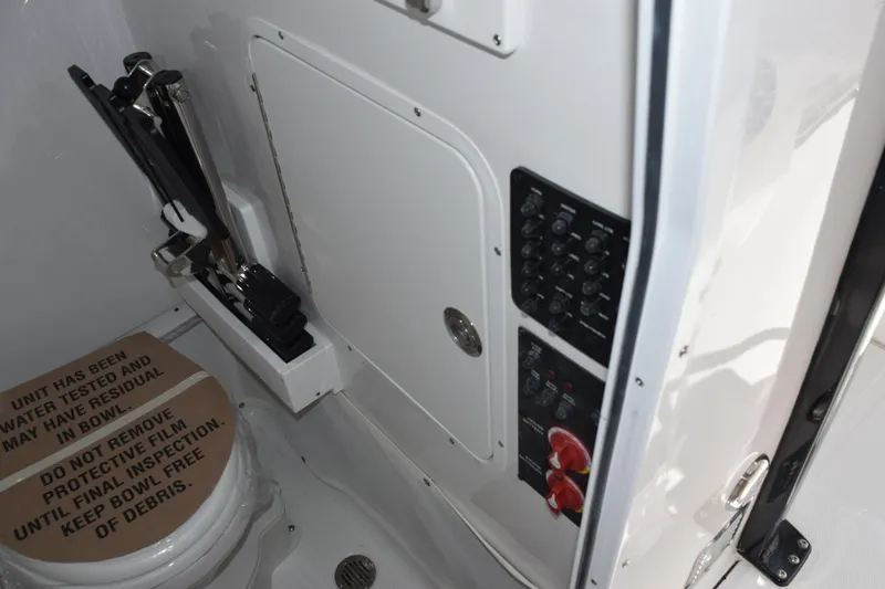 Slide: The Image of Interior of 2026 Sea Hunt Ultra 265 SE boat, featuring a compact restroom with control panel. - 17