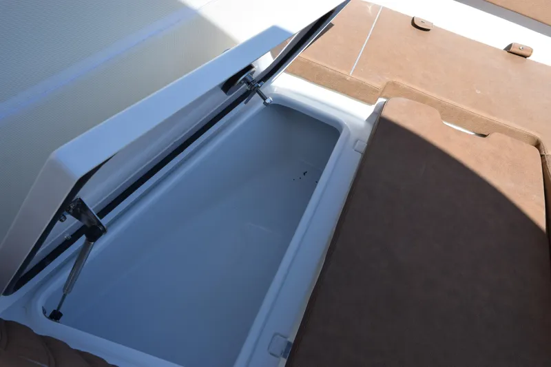 Slide: The Image of Open storage compartment on 2026 Sea Hunt Ultra 265 SE boat, featuring cushioned seating. - 18