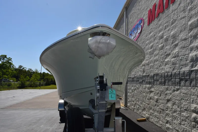 Slide: The Image of 2026 Sea Hunt Ultra 265 SE boat on trailer, parked beside a building. - 3