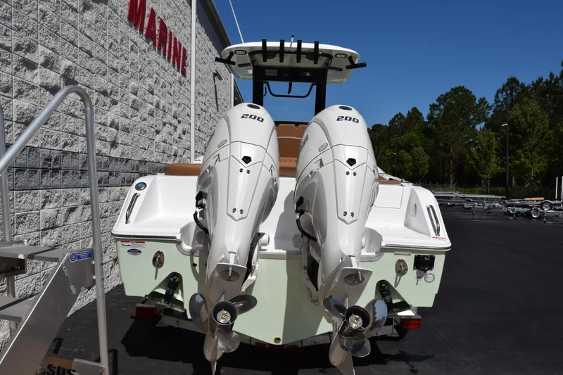 Slide: The Image of 2026 Sea Hunt Ultra 265 SE boat with dual 200 horsepower engines, parked outdoors. - 5