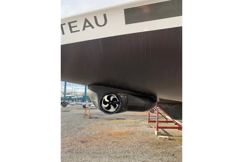 Slide: The Image of 2023 Beneteau Oceanis 34.1 yacht hull with visible bow thruster in a marina. - 11