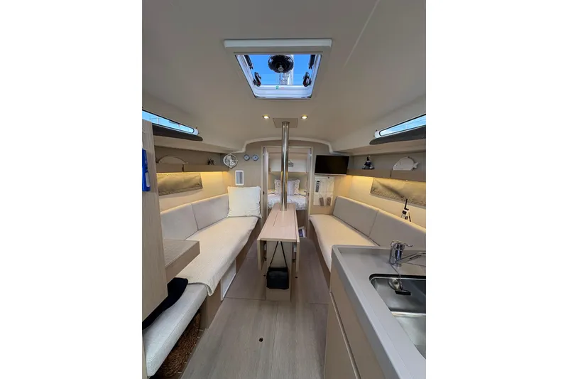 Slide: The Image of Interior of 2023 Beneteau Oceanis 34.1 yacht, featuring modern seating and skylight. - 24