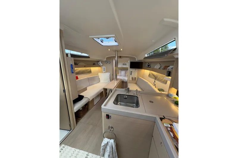 Slide: The Image of Interior of 2023 Beneteau Oceanis 34.1 yacht, featuring modern kitchen and cozy seating area. - 25