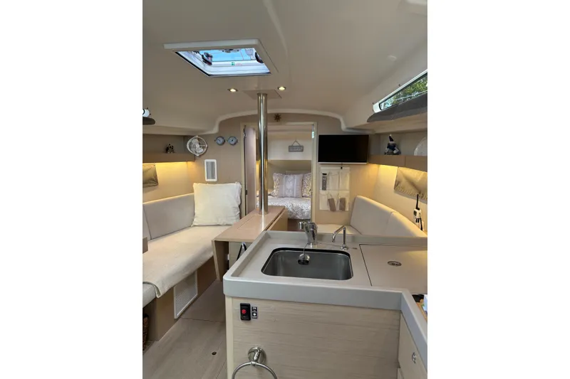 Slide: The Image of Interior of 2023 Beneteau Oceanis 34.1 yacht, featuring modern kitchen and cozy seating area. - 26