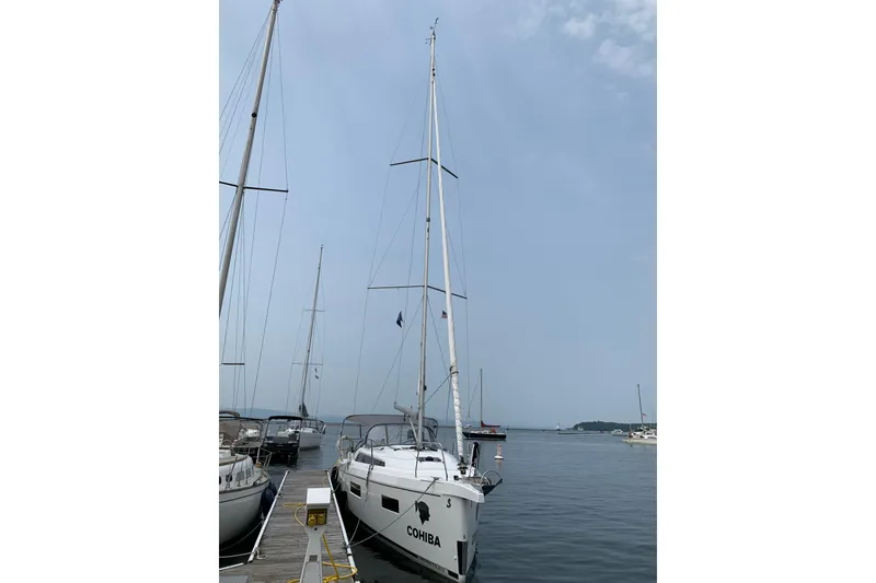 Slide: The Image of 2023 Beneteau Oceanis 34.1 sailboat docked at a marina under a clear sky. - 4