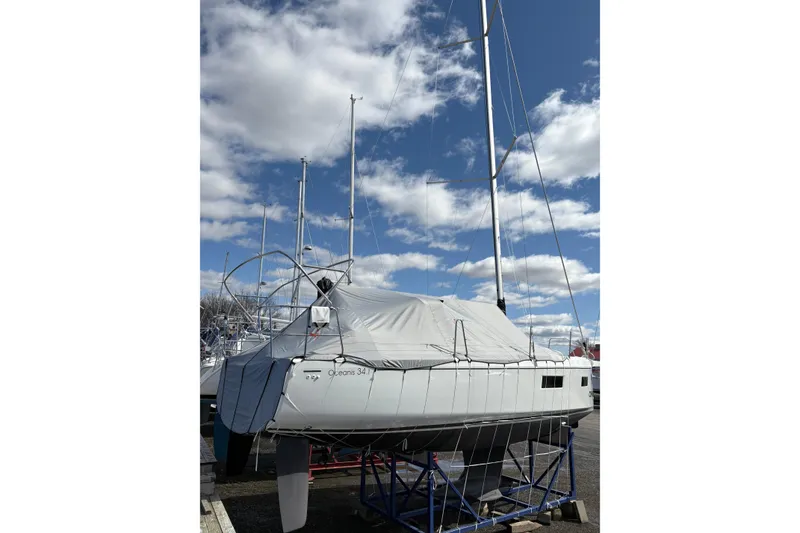 Slide: The Image of 2023 Beneteau Oceanis 34.1 sailboat on dry dock under a cloudy sky. - 8