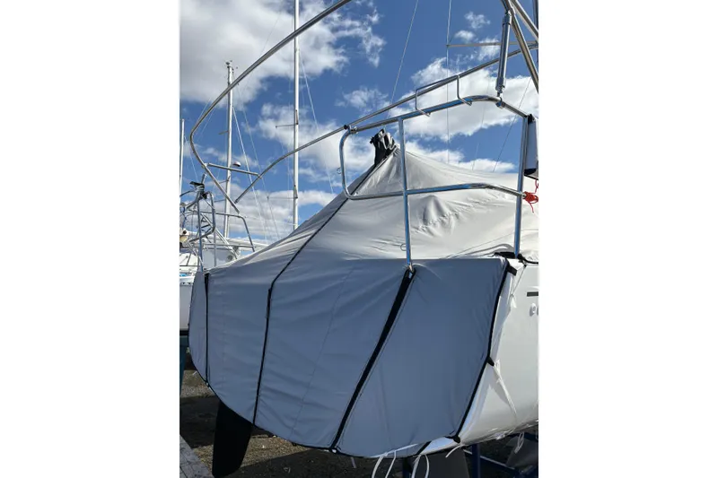 Slide: The Image of 2023 Beneteau Oceanis 34.1 sailboat covered, docked under a blue sky. - 9