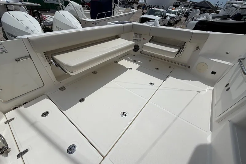 Slide: The Image of 2023 Boston Whaler 325 Conquest boat deck with foldable seating and storage compartments. - 11