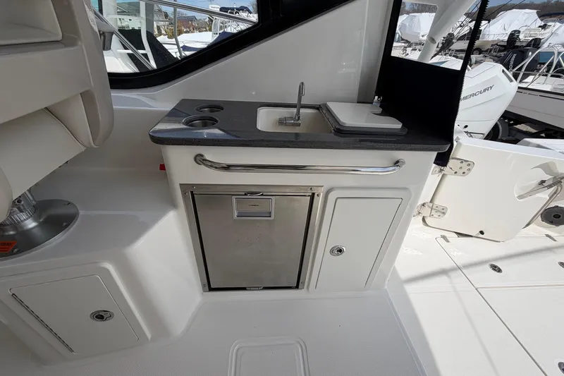 Slide: The Image of 2023 Boston Whaler 325 Conquest boat interior with sink and storage area. - 15