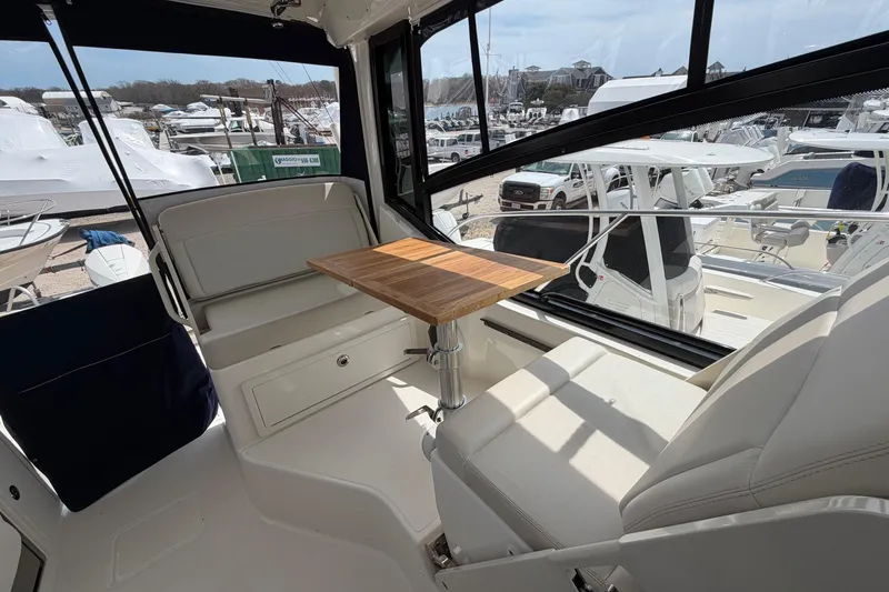 Slide: The Image of Interior of 2023 Boston Whaler 325 Conquest with seating and wooden table. - 16