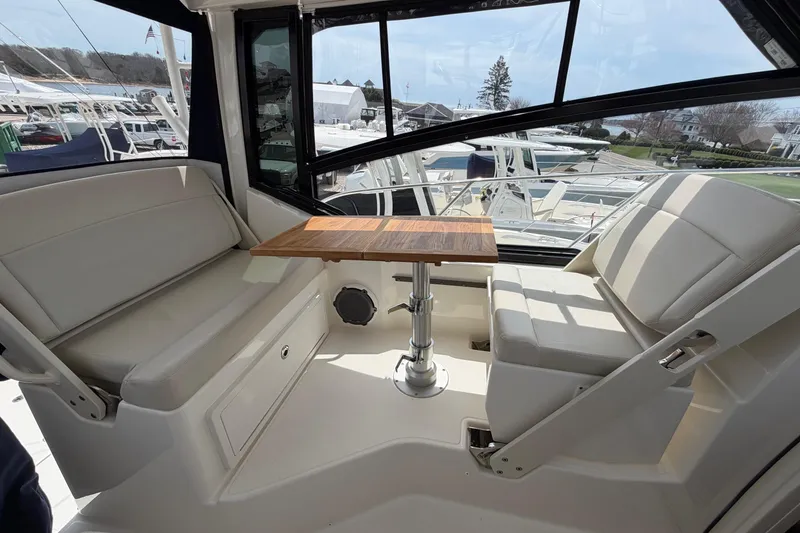 Slide: The Image of 2023 Boston Whaler 325 Conquest interior with seating and wooden table. - 17