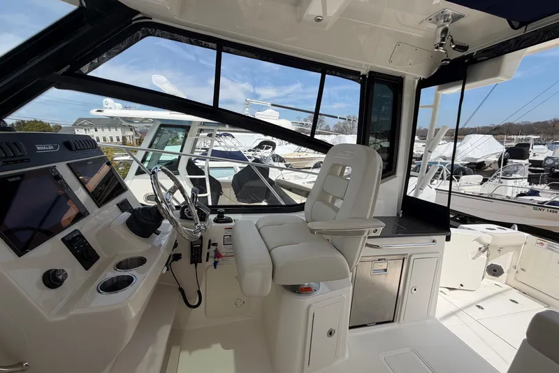 Slide: The Image of 2023 Boston Whaler 325 Conquest helm with modern controls and comfortable seating. - 19